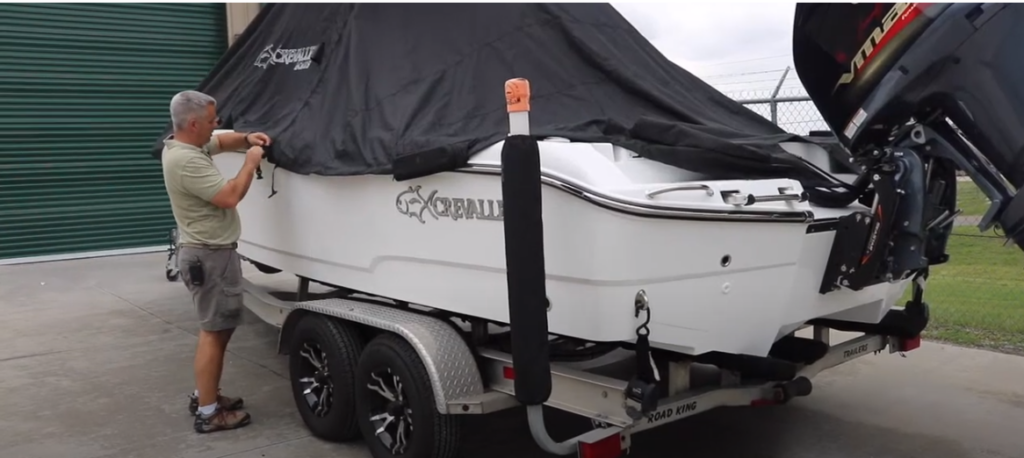 Man removing the cover of a Crevalle Boat