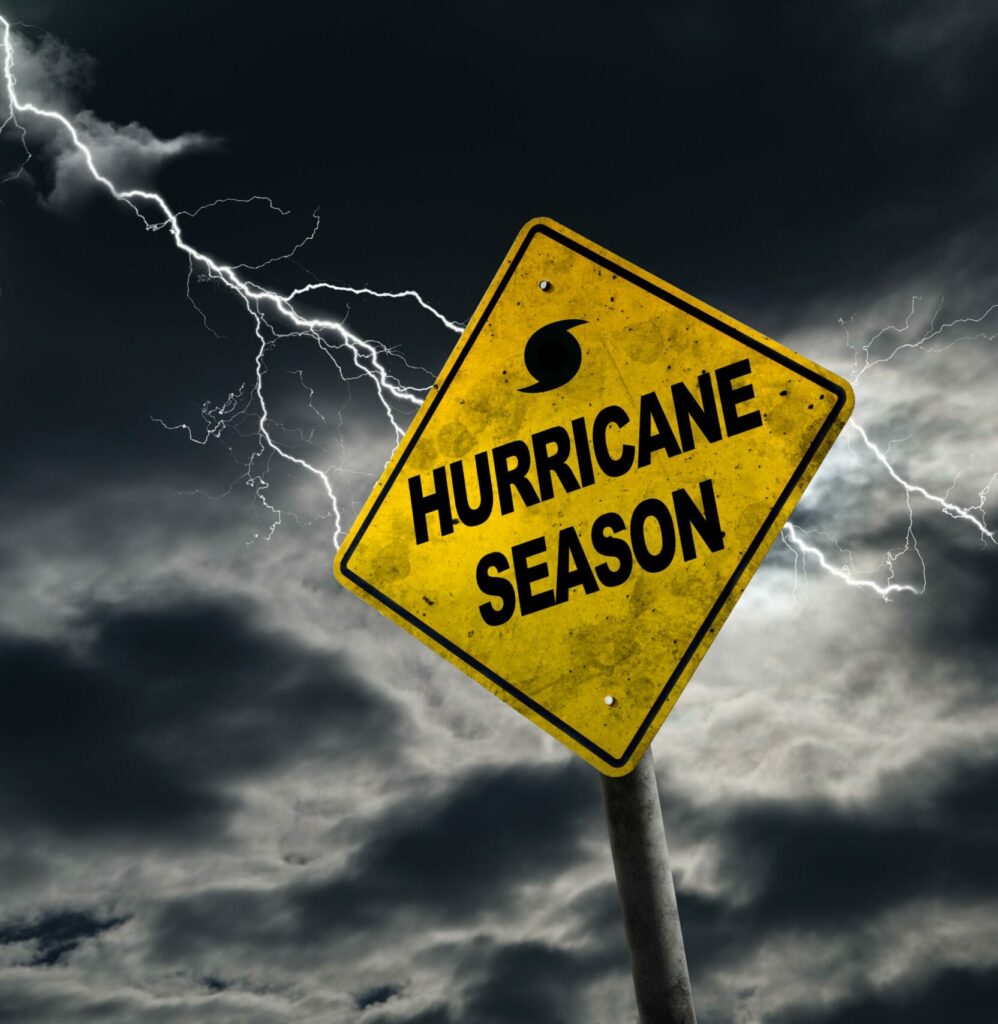 Yellow sign that says "Hurricane Season" With clouds and lightning in the background