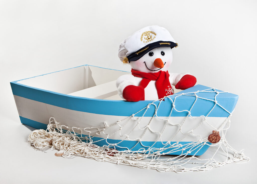 snowman in a captains hat sitting in a rowboat