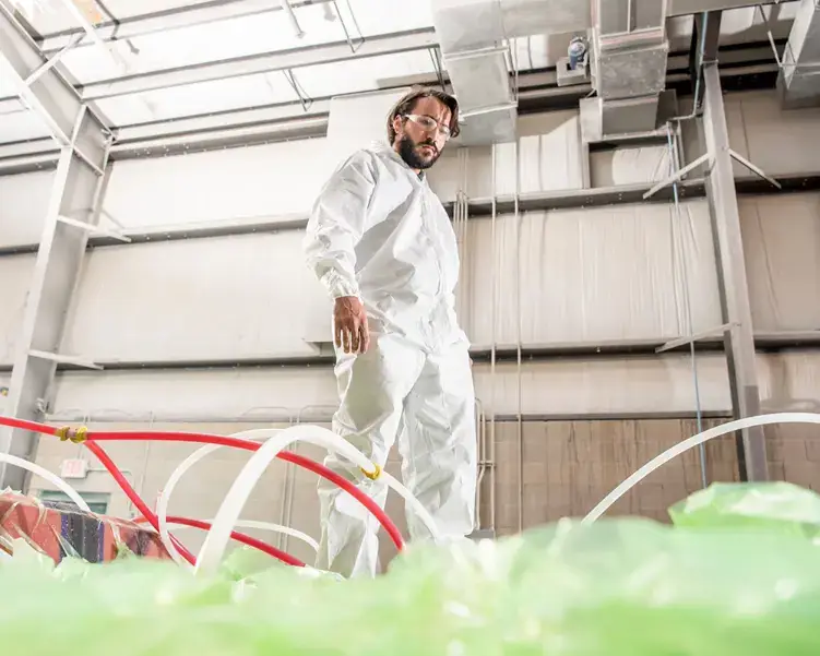 Crevalle Boats team member standing on a hull during the resin infusion process using CRIMP technology.