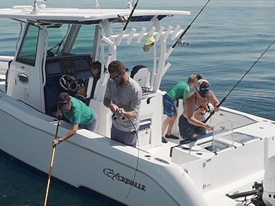 Image of a family fishing off of a Crevalle boat